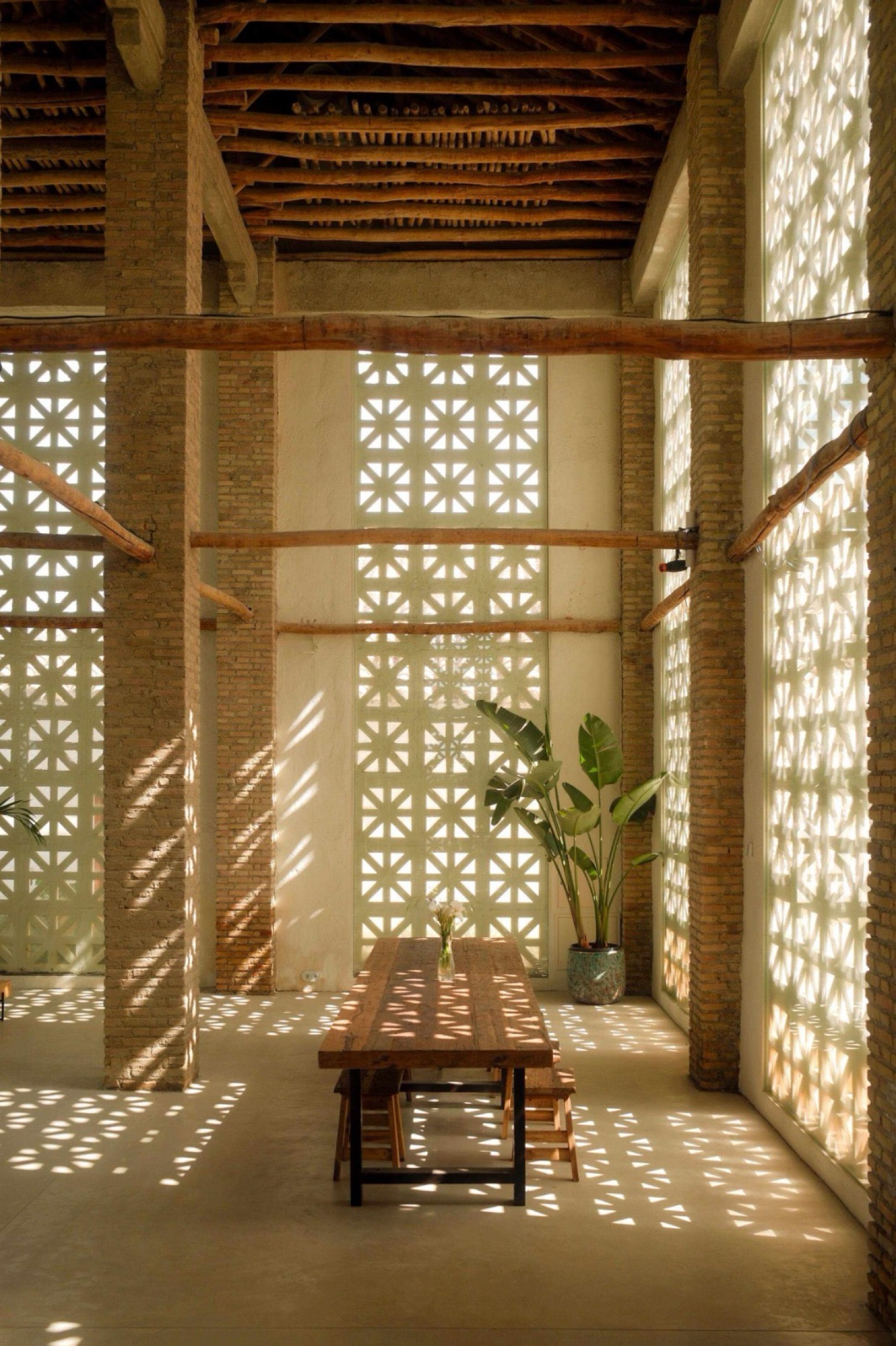 Interior del Cortijo de la Seda: mesa de madera, celosías y luz natural